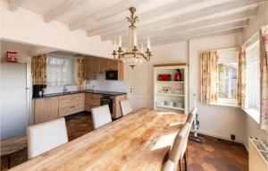 维斯桃特Cozy Home In Westouter With House A Panoramic View的厨房配有木桌和吊灯。