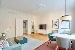 哥本哈根Large & Stylish Flats in Trendy & Vibrant Neighbourhood的客厅配有桌子和电视