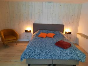 韦姆Le Grand Ravel的一间卧室配有带橙色枕头和椅子的床