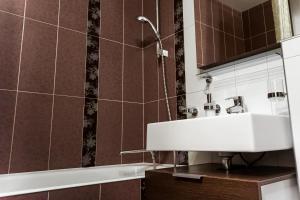 第聂伯罗Doba In Ua Peremoga Apartments的浴室配有盥洗盆和浴缸。