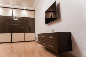 第聂伯罗Doba In Ua Peremoga Apartments的更衣室设有储物柜和墙上的电视