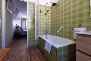 尼姆Rougetomette的带浴缸和玻璃淋浴间的浴室。