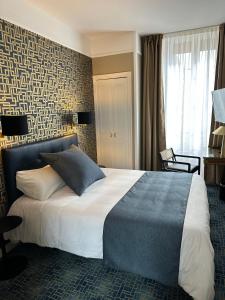 贝叶Churchill Hotel Bayeux Centre的一间卧室,卧室内配有一张大床
