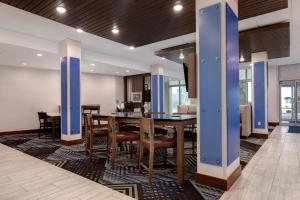 安娜堡Holiday Inn Express & Suites - Ann Arbor - University South, an IHG Hotel的一间带桌椅的用餐室
