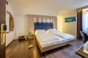 苏黎世Hotel Alexander Zurich Old Town的一间卧室配有一张大床和蓝色床头板