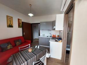斯卡莱阿Katia's Home的一间带红色沙发的客厅和一间厨房