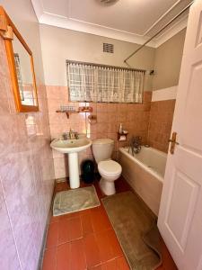 布隆方丹Farm stay at Rosemary Cottage on Haldon Estate的浴室配有卫生间、盥洗盆和浴缸。