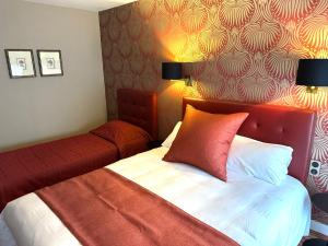 贝叶Churchill Hotel Bayeux Centre的一间卧室配有一张红色床头板的床