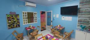 马瑙斯Hotel Colors Manaus的一间拥有蓝色墙壁和桌椅的用餐室