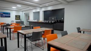 Santa InêsHotel Tupinambá的用餐室配有桌子和橙色椅子