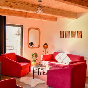 苏希采Rezidence Valcha的客厅配有2把红色椅子和桌子