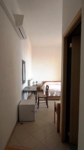 皮蒂利亚诺Residenza Pitigliano的卧室配有1张床、1张桌子和1把椅子