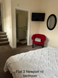斯塔福德Stafford apartments的一间卧室配有一张床、一张红色椅子和一面镜子