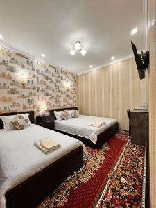 撒马尔罕Hamida的酒店客房设有两张床和电视。