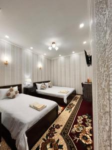撒马尔罕Hamida的酒店客房设有两张床和电视。
