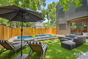 奥斯汀Modern Luxury Home - Minutes from Lady Bird Lake的后院设有游泳池和遮阳伞
