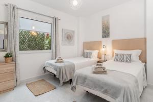 莫莱拉Apartamento mediterráneo en el alma de Moraira的白色的客房设有两张床和窗户。