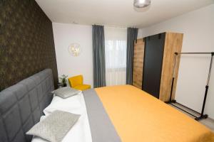 斯拉沃尼亚布罗德Apartman Lipa的一间卧室配有一张床和黄色毯子