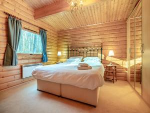 LegbourneForest Lodge的小木屋内一间卧室,配有一张床