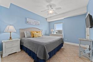 巴拿马城海滩Twin Palms 1705的蓝色卧室配有床和吊扇