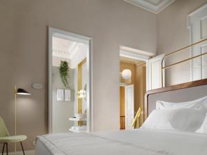 雅典Monument的卧室配有白色的床和镜子