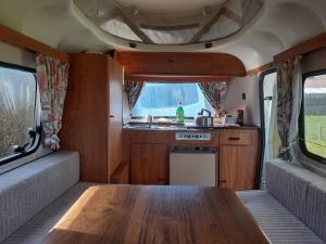 诺里奇Sundial Cottage Eriba Caravan的一间带木制餐桌的厨房