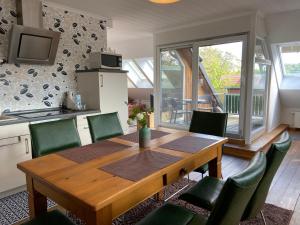措森Kleemann´s Apartment****的厨房以及带木桌和椅子的用餐室。