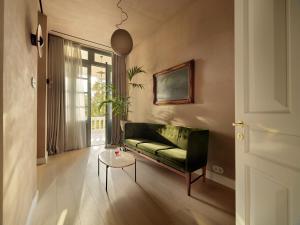 雅典Monument的客厅配有绿色沙发和桌子