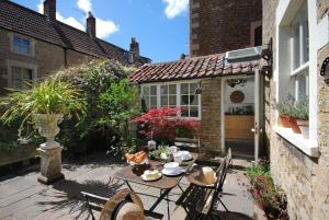 弗罗姆Charming Cottage in the Heart of Frome - Sun House的房屋前设有带桌椅的天井。