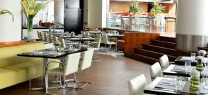 加拉加斯佩斯塔纳加拉加斯高级城市及会议酒店的用餐室配有桌子和白色椅子
