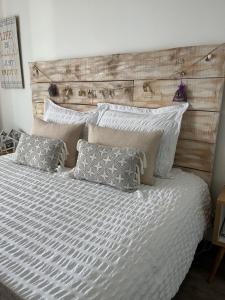 普罗旺斯艾克斯Studios Nuitée en Provence的一间卧室配有一张带木制床头板和枕头的床。