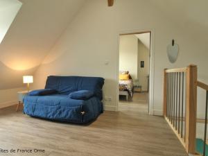 Soligny-la-TrappeGîte Soligny-la-Trappe, 3 pièces, 4 personnes - FR-1-497-174的客厅设有蓝色的沙发,卧室设有