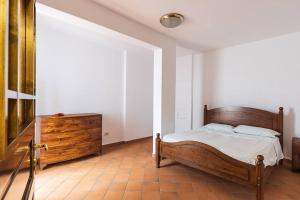 切法卢Casa al mare dei 7 Emiri的一间卧室配有木床和梳妆台