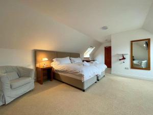 多诺赫Balloan Steading West的一间卧室配有一张床、一把椅子和镜子