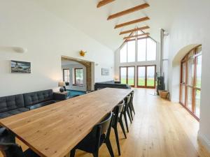多诺赫Balloan Steading West的客厅配有一张大木桌和沙发