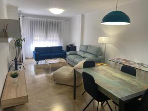 比列纳Apartamento Pandora, ideal para sentirte como en casa的客厅配有桌子和蓝色沙发