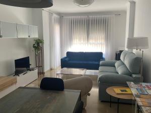 比列纳Apartamento Pandora, ideal para sentirte como en casa的客厅配有蓝色的沙发和桌子
