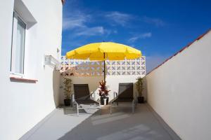 巴尔韦尔德Casa La Balaustrada的天井配有两把椅子和黄色雨伞