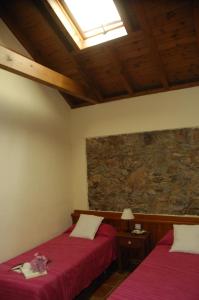 巴列埃尔莫索棕榈乡村民宿的一间卧室设有两张床和石墙