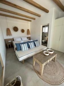 斯希努萨岛Sohoros Luxury Suites的一间卧室配有一张带蓝色和白色枕头的床