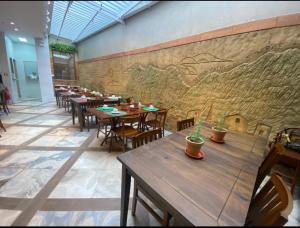 塞拉塔利亚达EMA HOTEL的一间带木桌和椅子的餐厅以及壁画