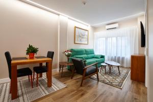 萨莫拉泽尼特两公主酒店的客厅配有绿色沙发和桌子