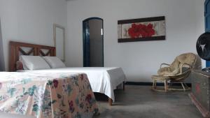 帕拉蒂Refúgio Ouro Fino Kitnets Casas e Apartamentos的一间卧室配有两张床、椅子和一幅画