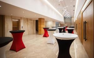 地拉那Doanesia Premium Hotel & Spa的大堂设有一排红色和黑色凳子