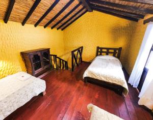 El CocuyHotel Museo la Posada del Molino的客房设有两张床和壁炉。