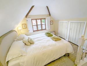 奇切斯特Truffle Cottage, Chichester的卧室配有带枕头的大型白色床