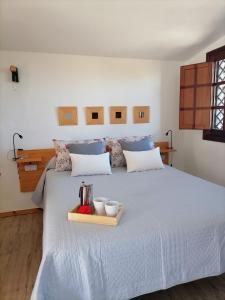 伊科德洛斯维诺斯LA TAGORA Conect with the nature & relax的一间卧室配有一张床,上面放着一个食物托盘