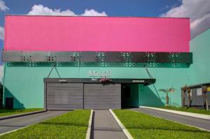 圣保罗Soft Motel - USP的一座粉红色墙壁和车库的建筑