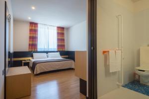 赛拉诺三鹿酒店的一间卧室配有一张床,浴室设有卫生间