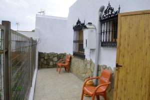 巴尔巴特Alojamiento el Chaparro Barbate junto a la venta el loro的庭院设有两把椅子和围栏